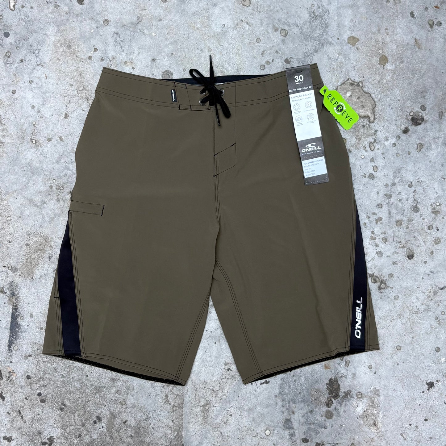 Brown shorts with a brand tag on a textured gray surface