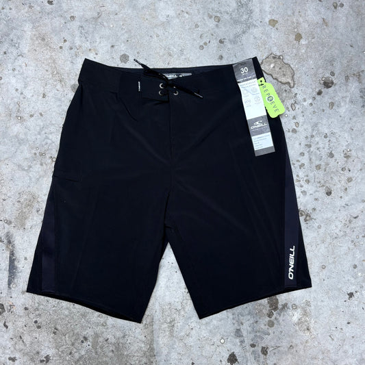 Black shorts with a brand tag on a concrete surface