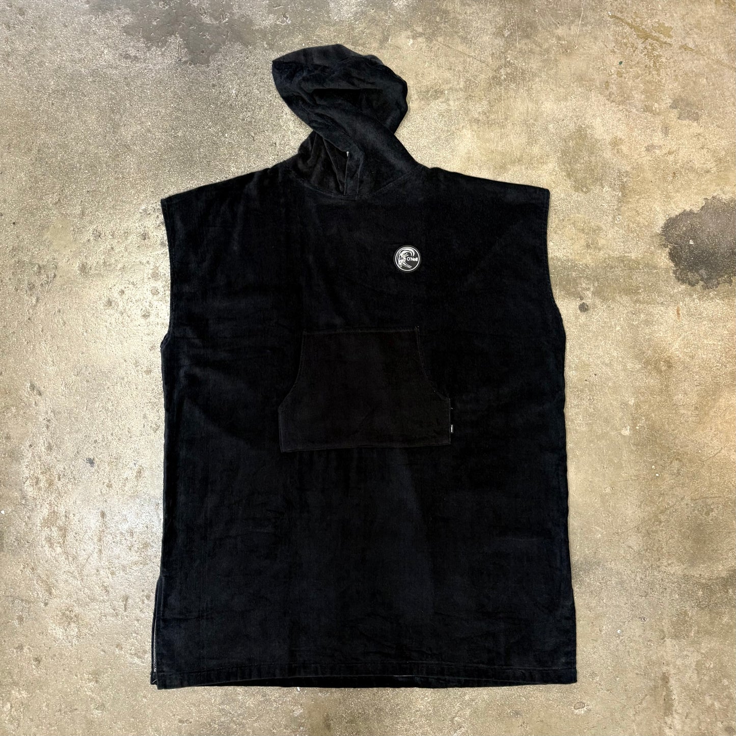Black sleeveless jacket with a logo on a textured surface