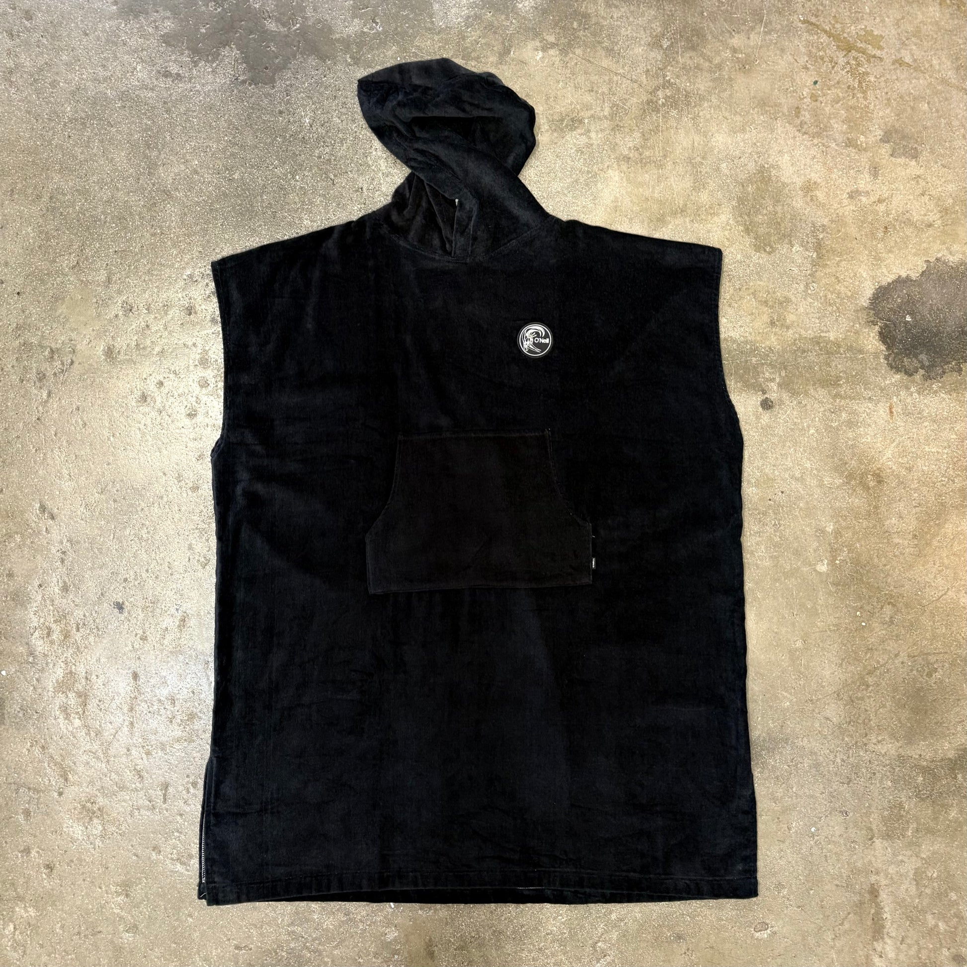 Black sleeveless jacket with a logo on a textured surface