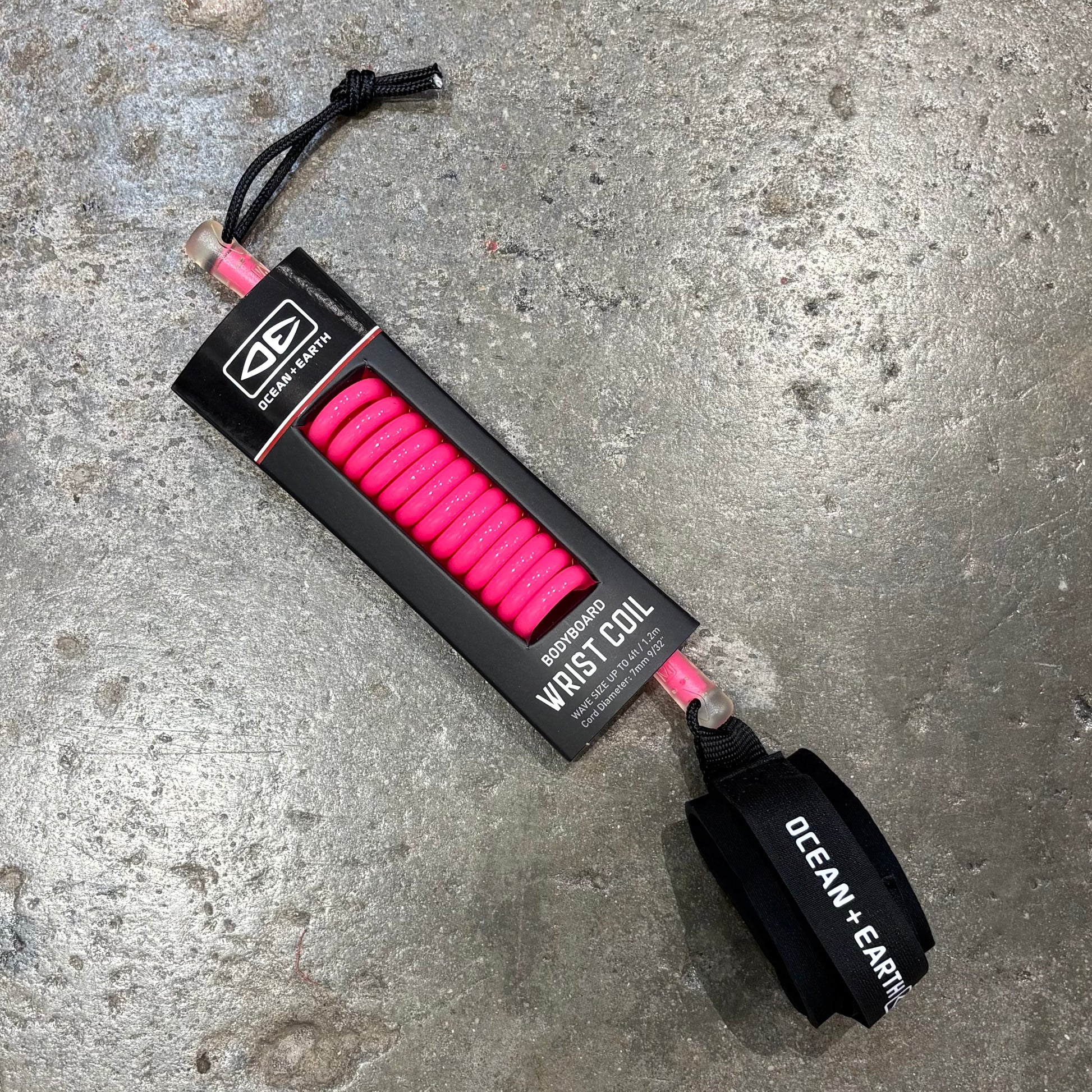 Pink wrist coil with black handle on a concrete surface