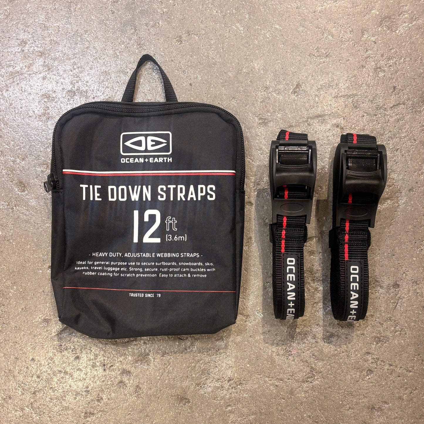 Black tie down straps with packaging on a concrete surface