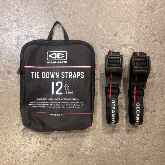 Black tie down straps with packaging on a concrete surface