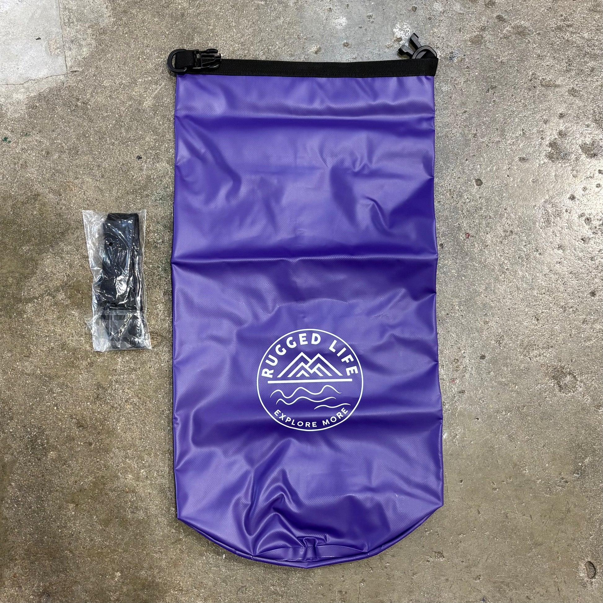 Purple dry bag with 'Rugged Life' logo on a concrete surface