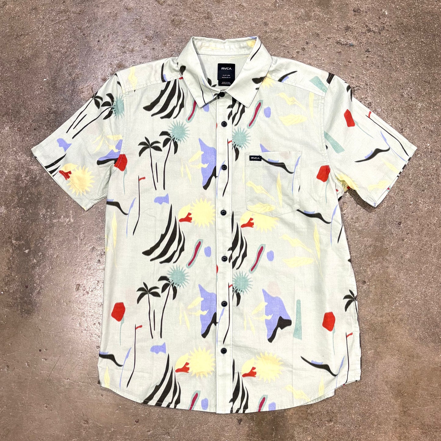Short-sleeve shirt with colorful abstract pattern on a brown surface