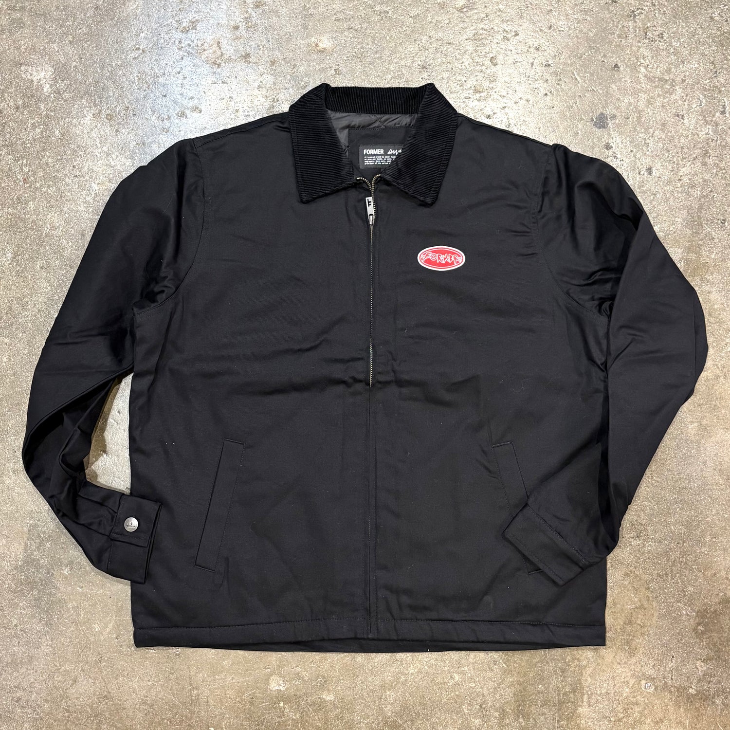 Black jacket with a logo on a textured surface