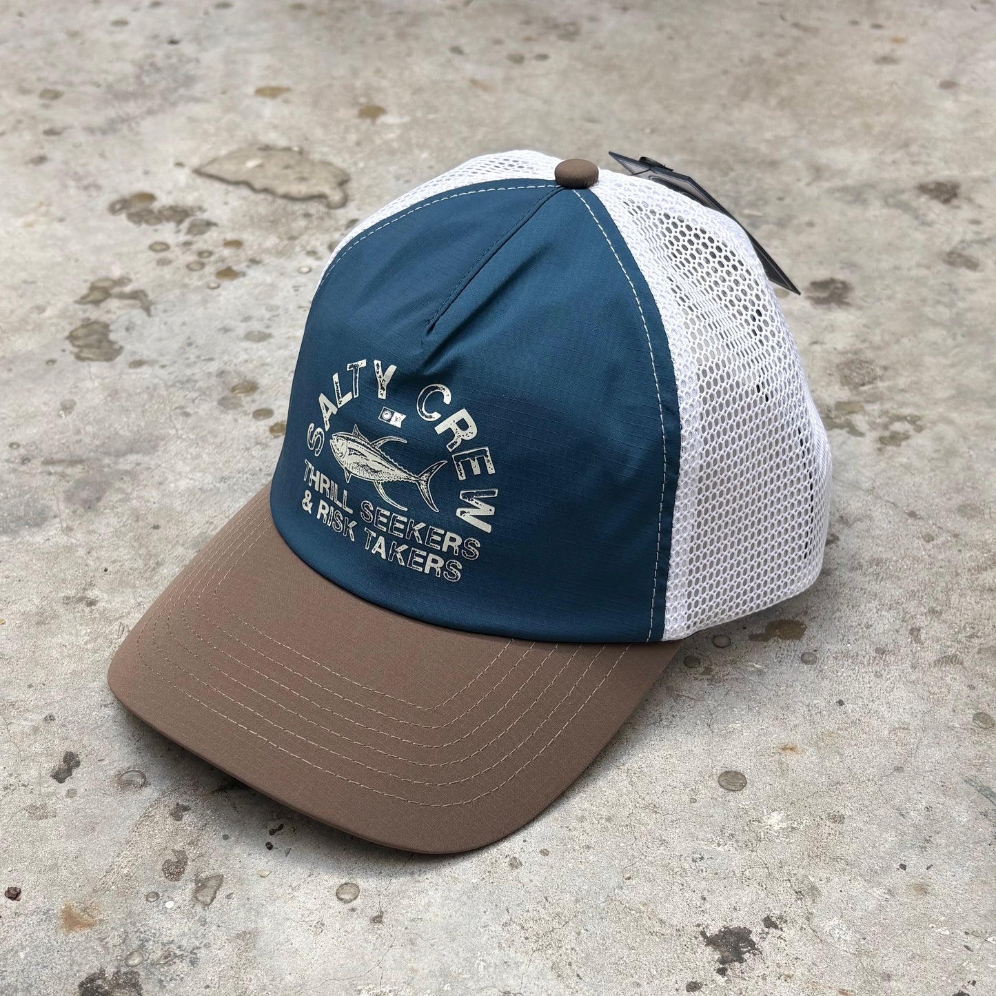 Blue and brown cap with mesh back on a concrete surface