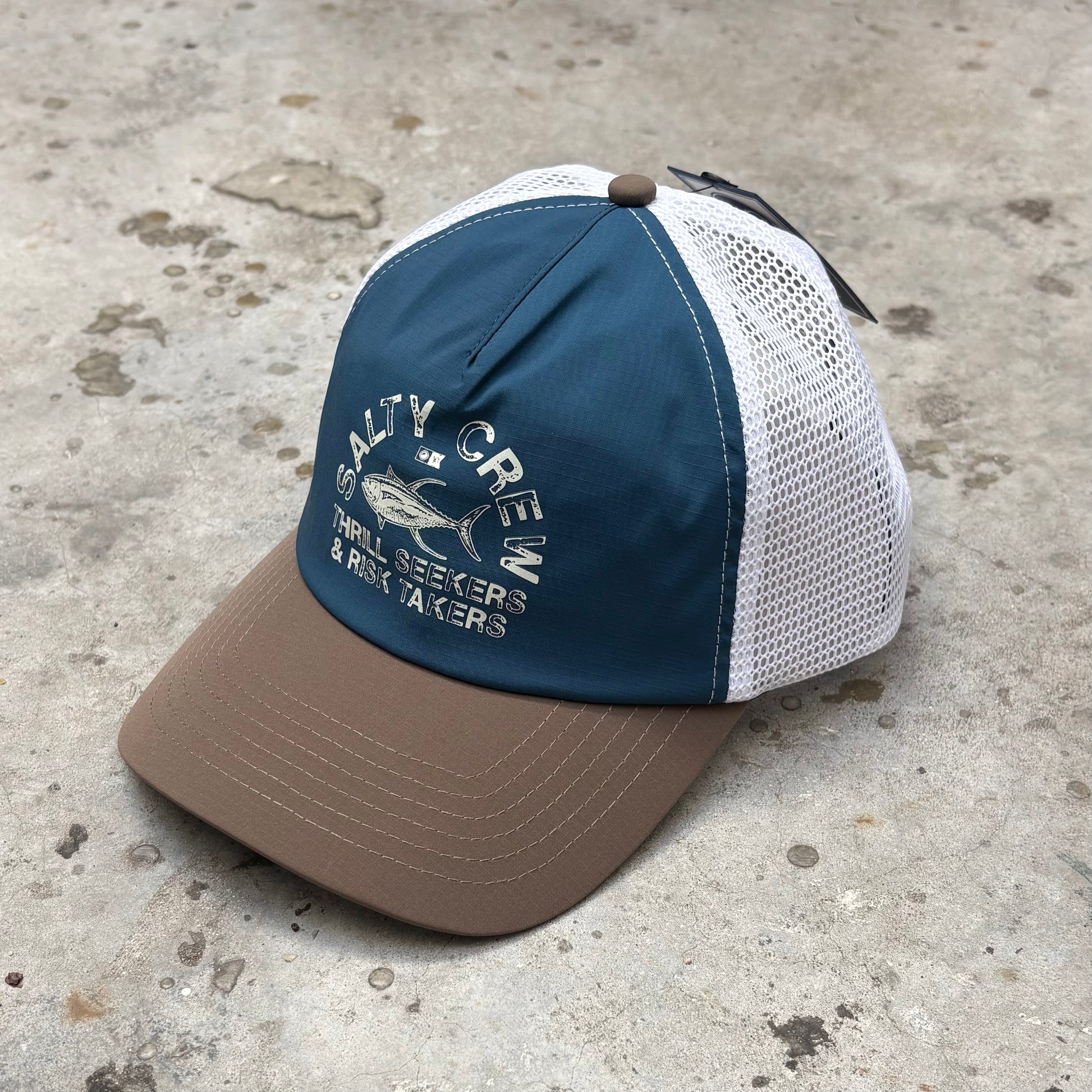 Blue and brown cap with mesh back on a concrete surface