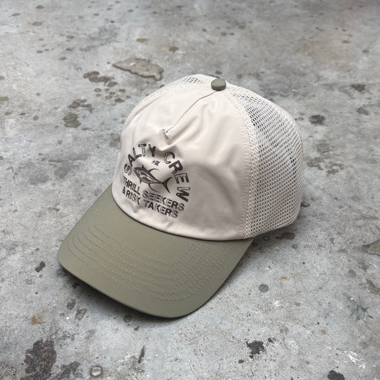 Beige and green cap with text on a concrete surface