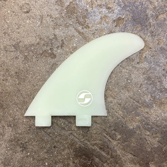 Light green surf fin with a logo on a textured brown surface