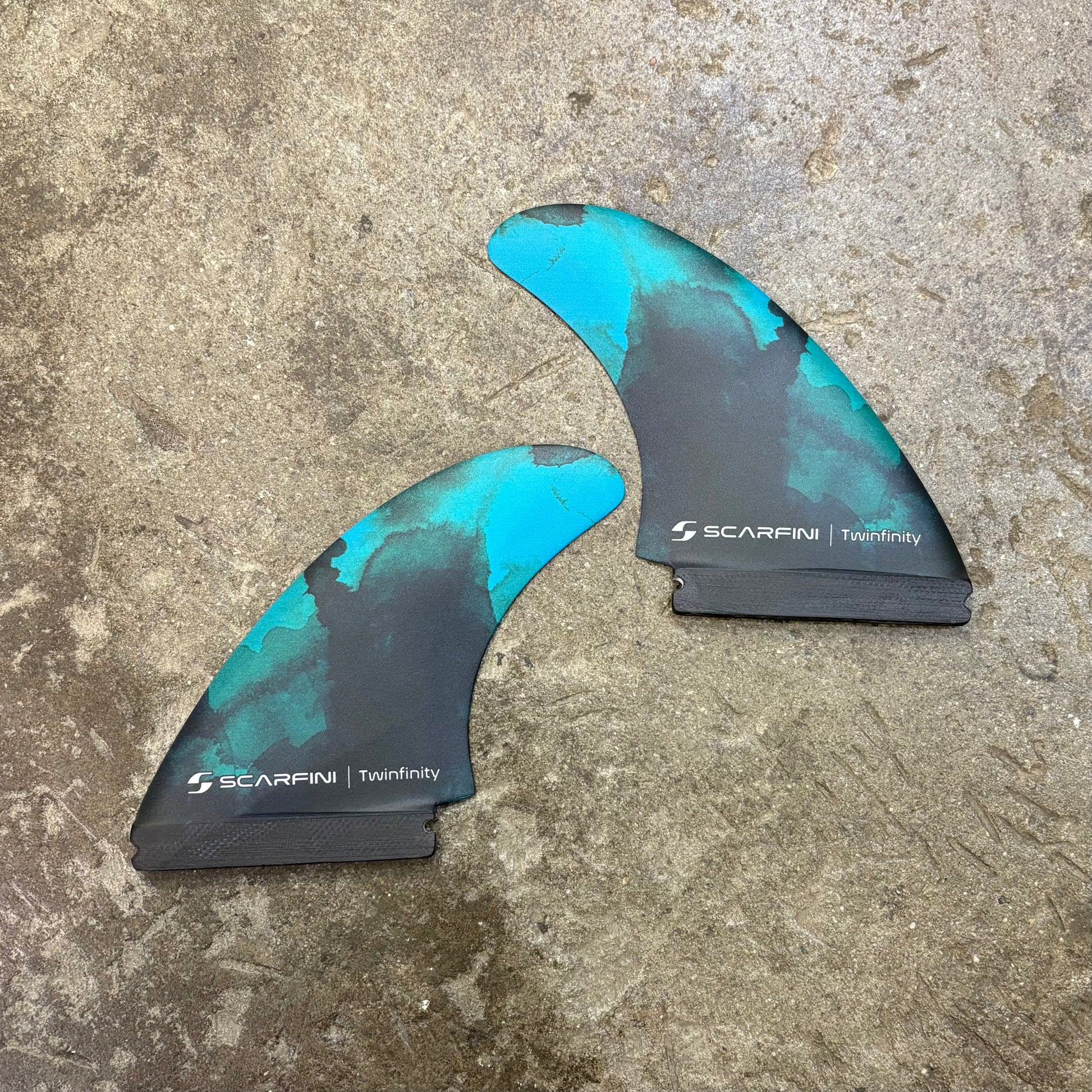 Surfboard fin with 'Scarfing' branding on a textured surface