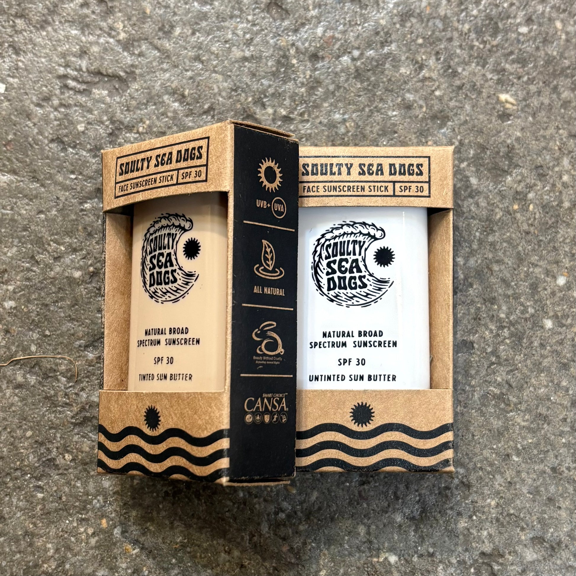 Sunscreen stick packaging with 'Squally Sea Dogs' branding on a textured surface