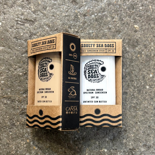 Sunscreen stick packaging with 'Squally Sea Dogs' branding on a textured surface