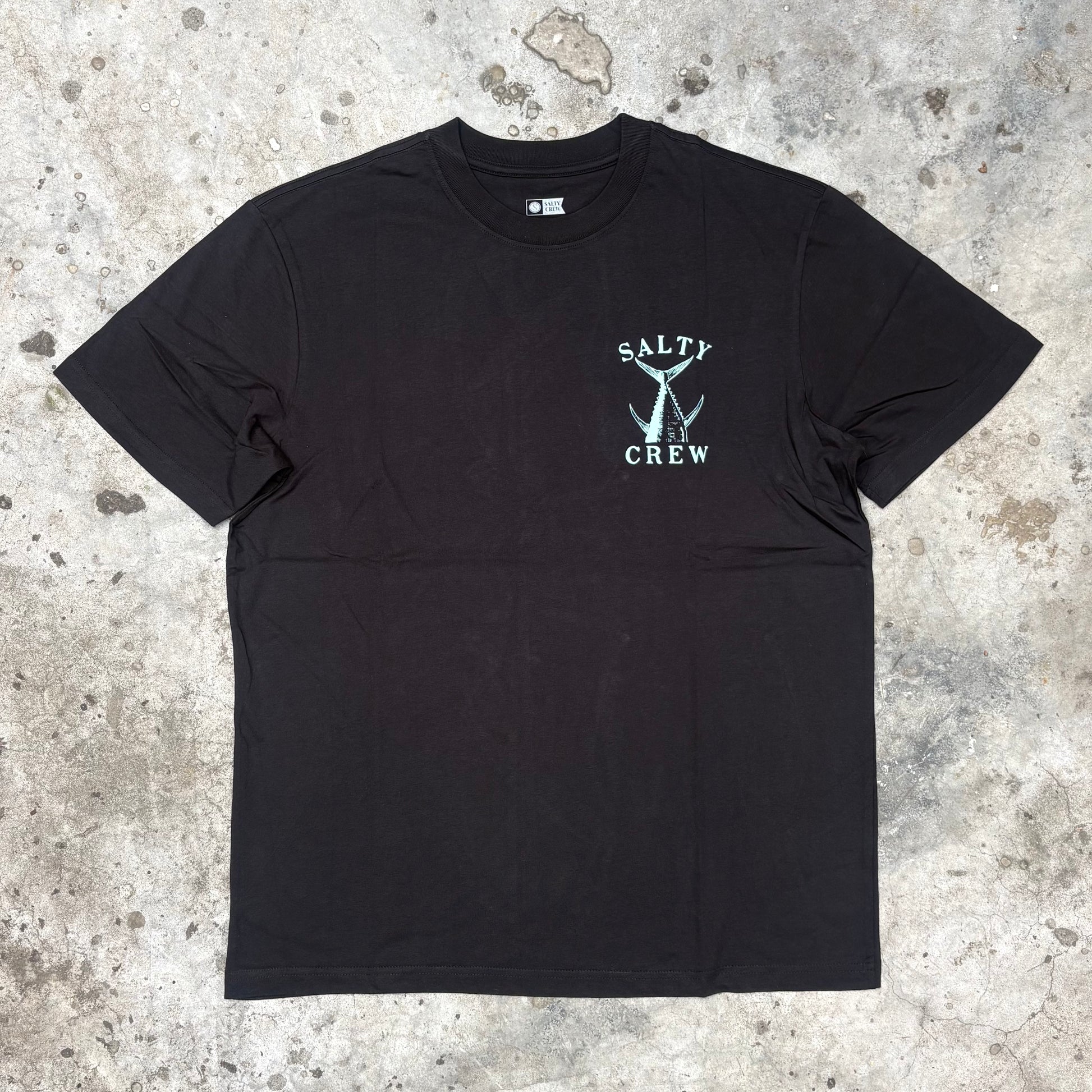Black t-shirt with 'Salty Crew' logo on a textured surface