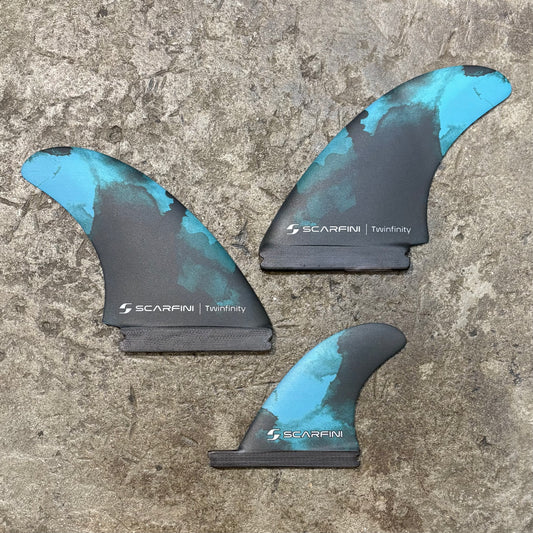 Set of Scarfini Twin Fin | Single Tab + Stabilizer on a concrete floor