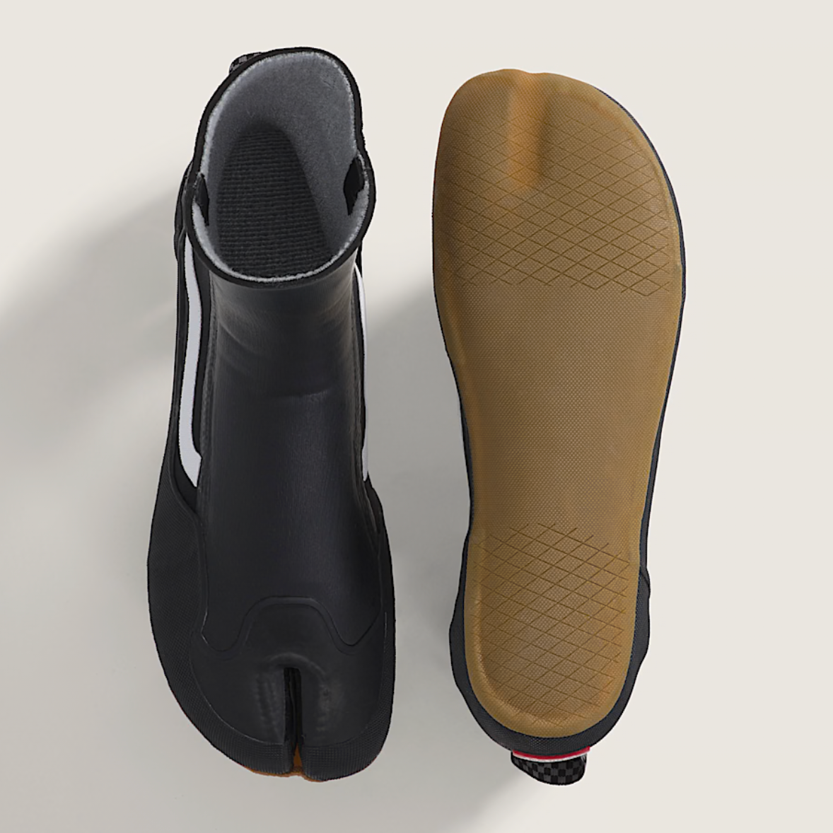 Black surf boot with brown sole on a light gray background