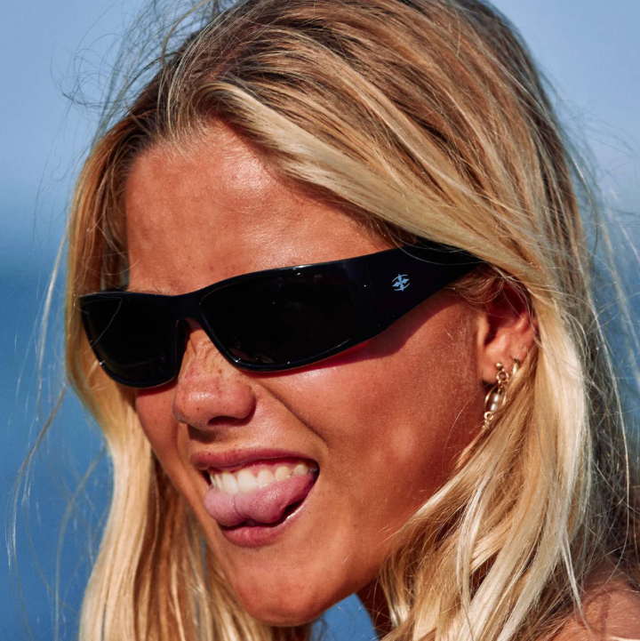 Woman wearing black sunglasses with a clear blue sky background