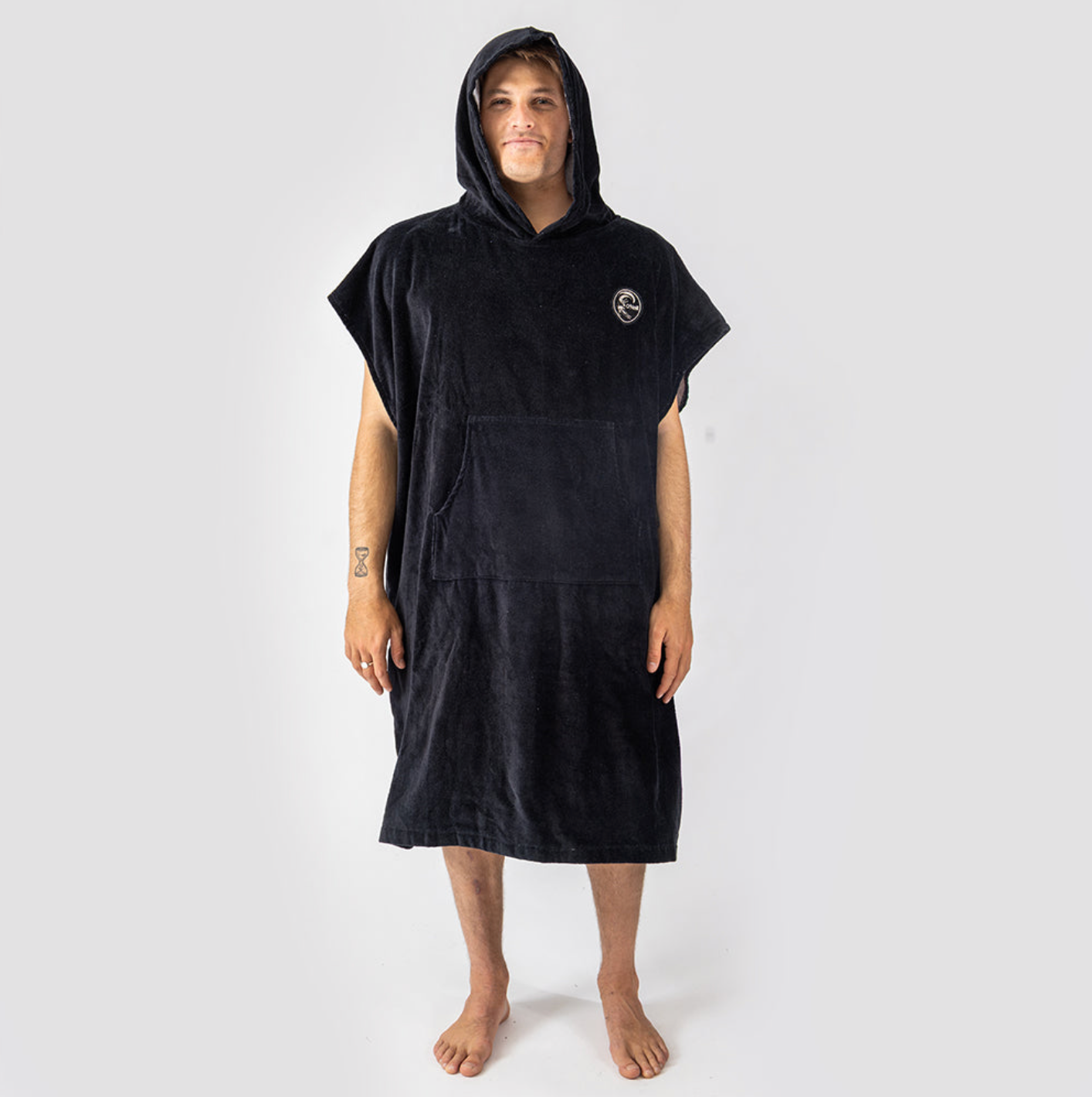 Person wearing a black hooded towel on a white background