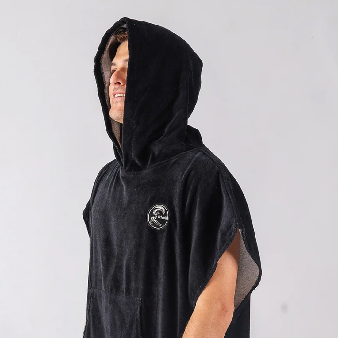Person wearing a black hooded towel with a logo on a white background