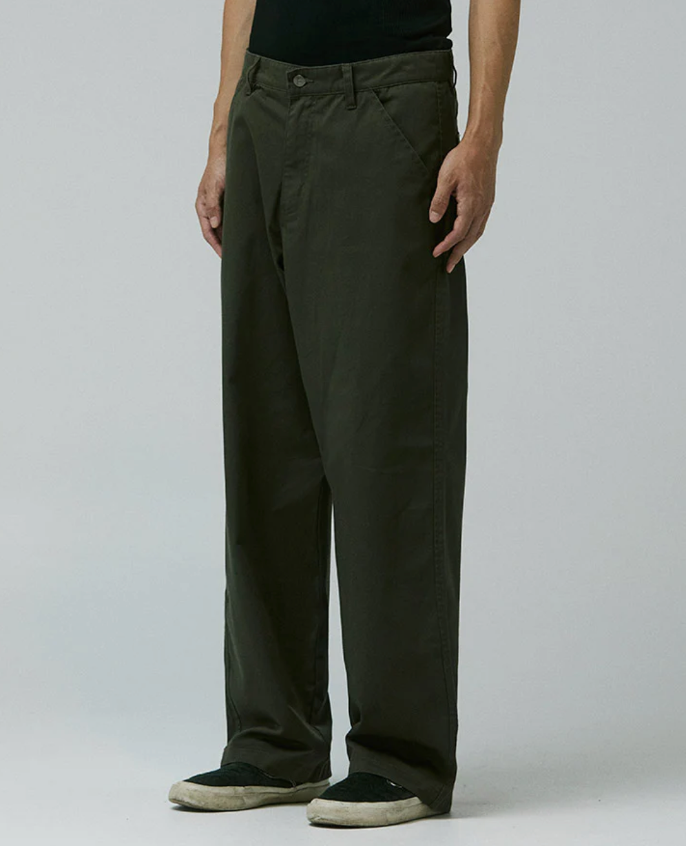Person wearing dark green pants on a gray background