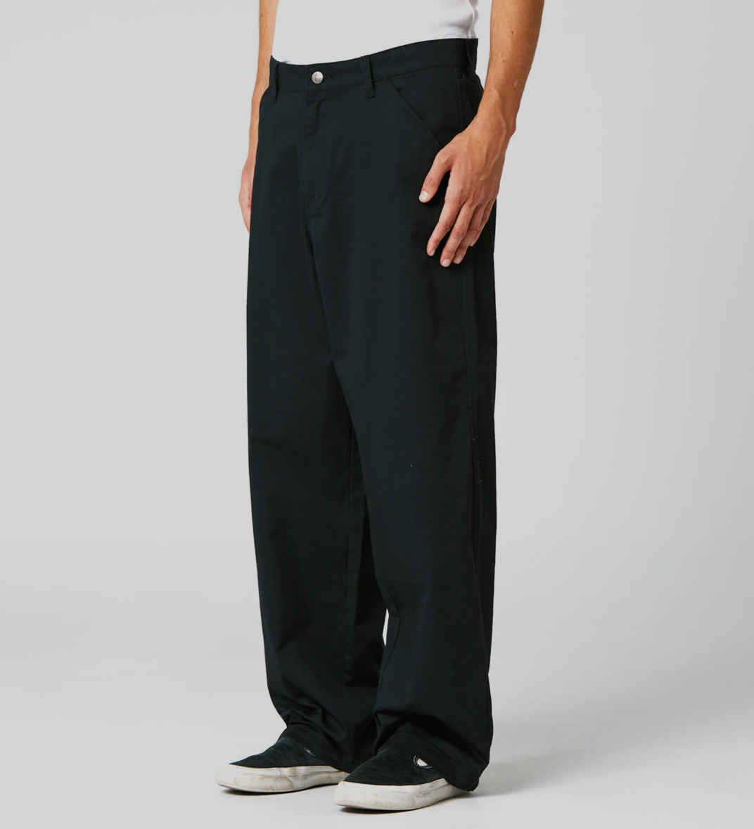 Person wearing black pants on a plain background