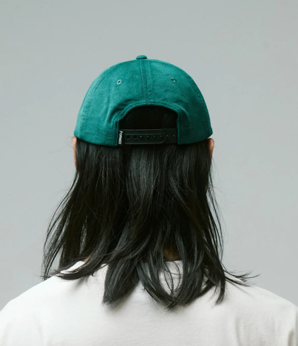 Person wearing a green cap with a plain background