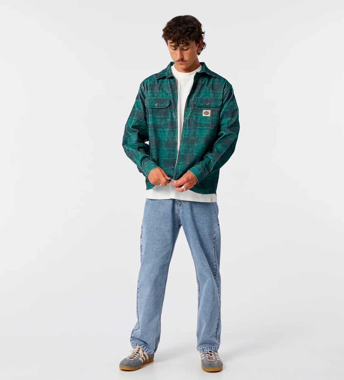 Person wearing a green plaid shirt and blue jeans on a white background