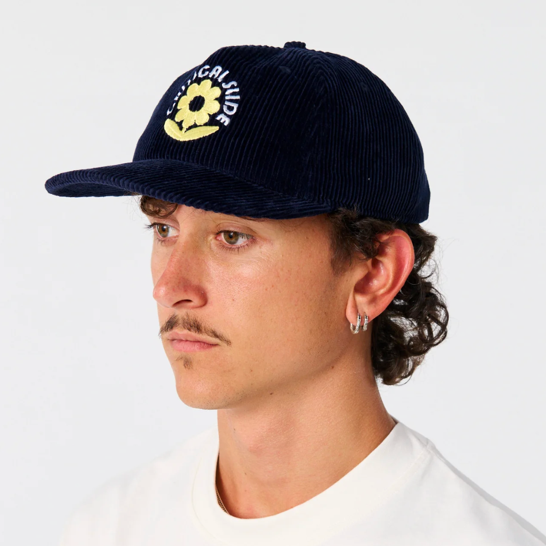Person wearing a navy blue cap with a yellow logo on a white background