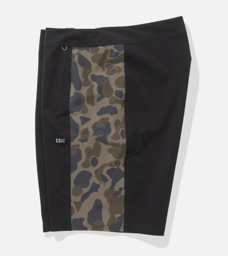 Black surf shorts with a vertical camouflage panel on the left side, featuring a side pocket and a small logo tag, shown on a light gray background.