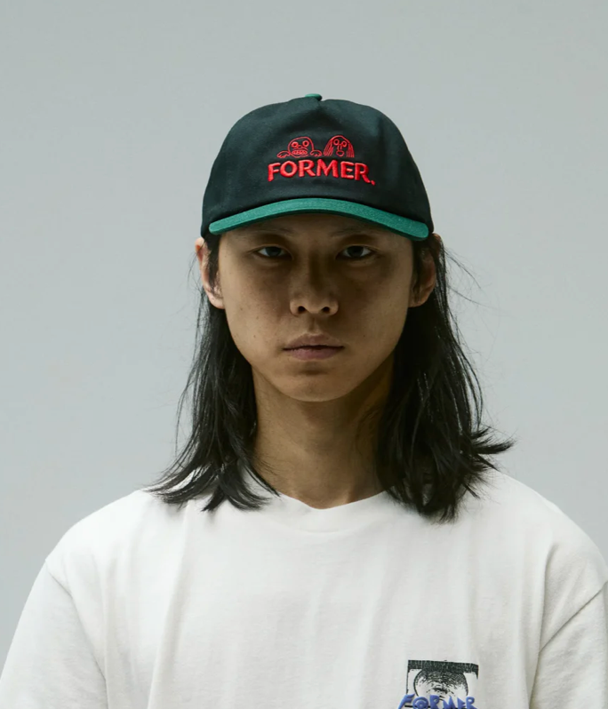 Person wearing a black cap with red text on a gray background