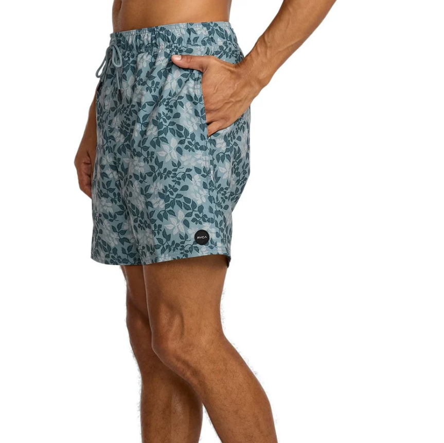 Person wearing blue floral patterned shorts on a white background