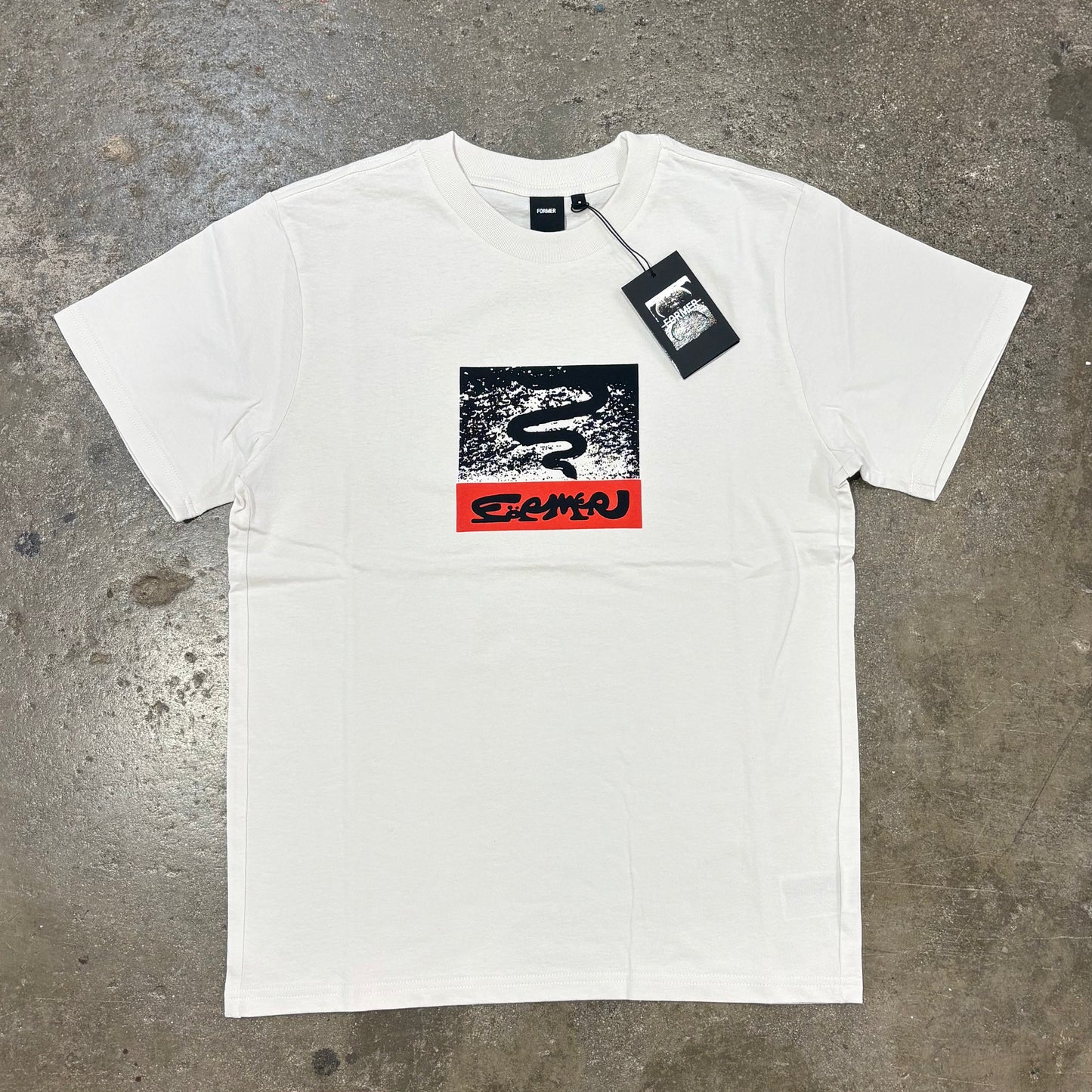 White T-Shirt with logo on concrete surface