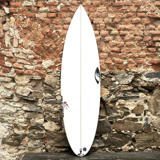 White Sharpeye_Surfboard_File_Fifty surfboard with a logo against a rustic stone wall