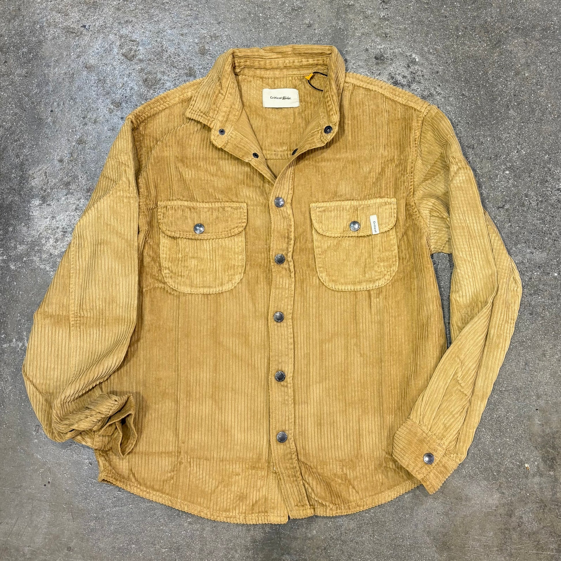 Yellow corduroy shirt on a textured gray surface