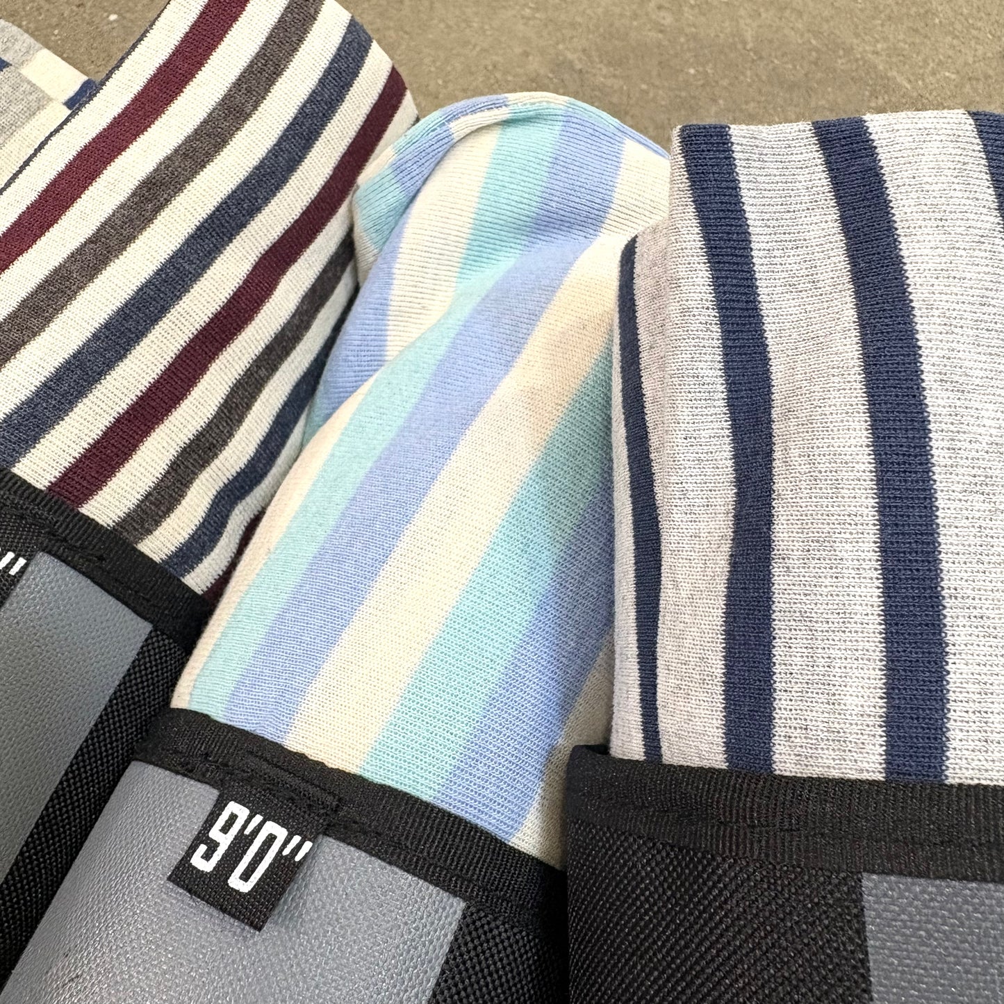 Striped Surfboard socks with a Hurricane brand label on a textured surface