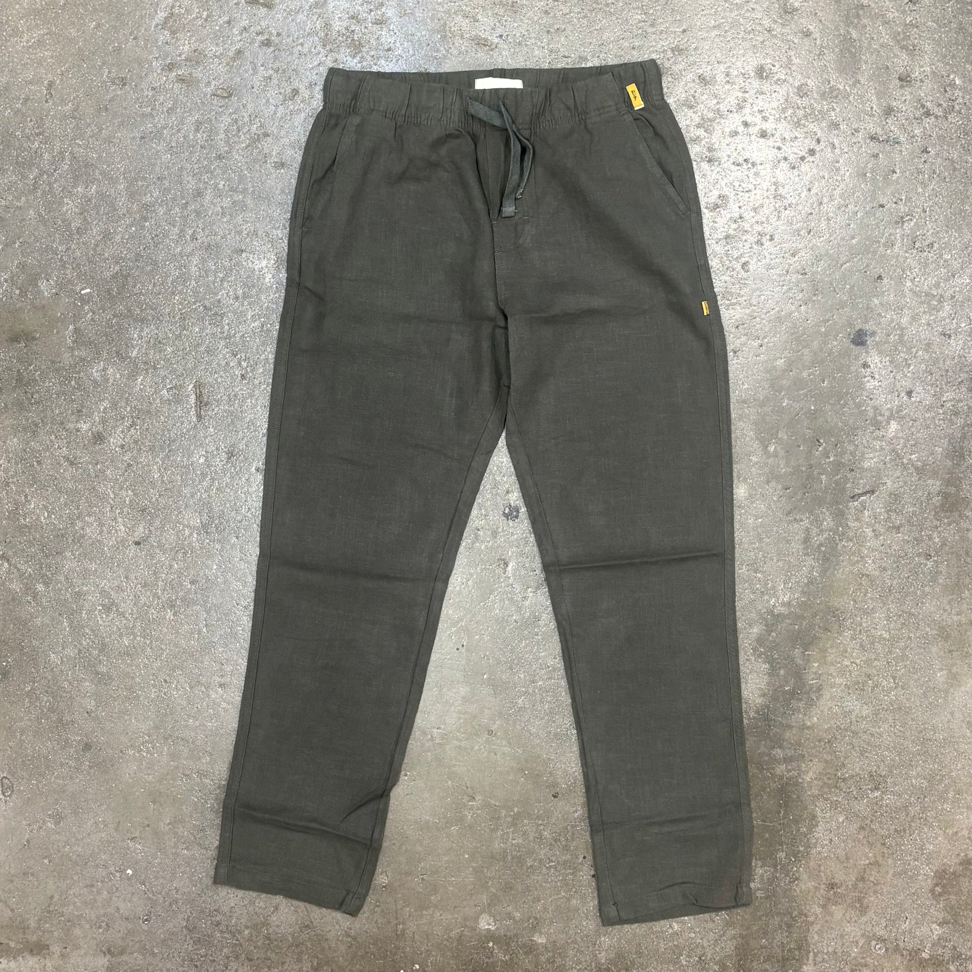 Dark green pants on a concrete floor