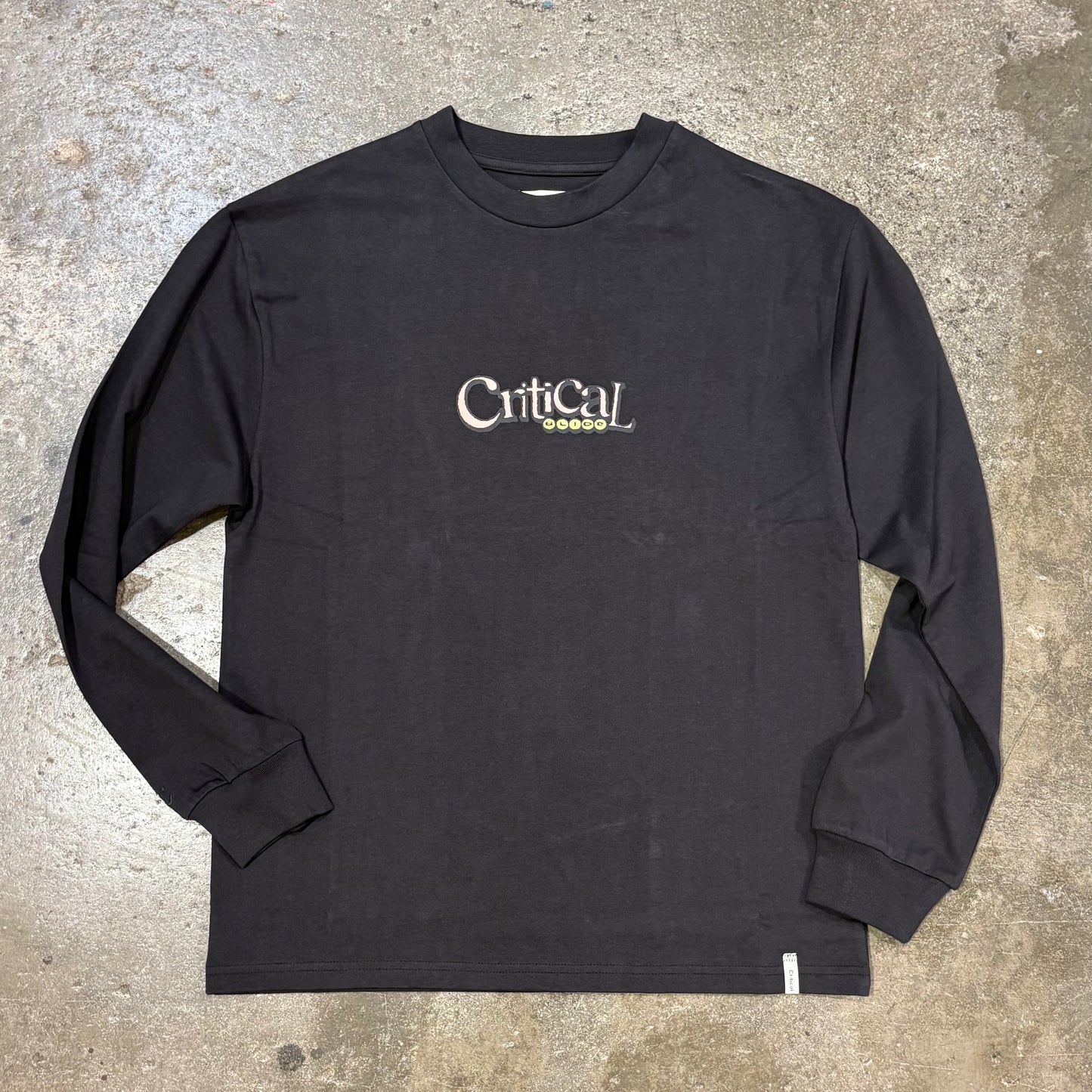 Black long-sleeve shirt with 'Critical' logo on a concrete surface