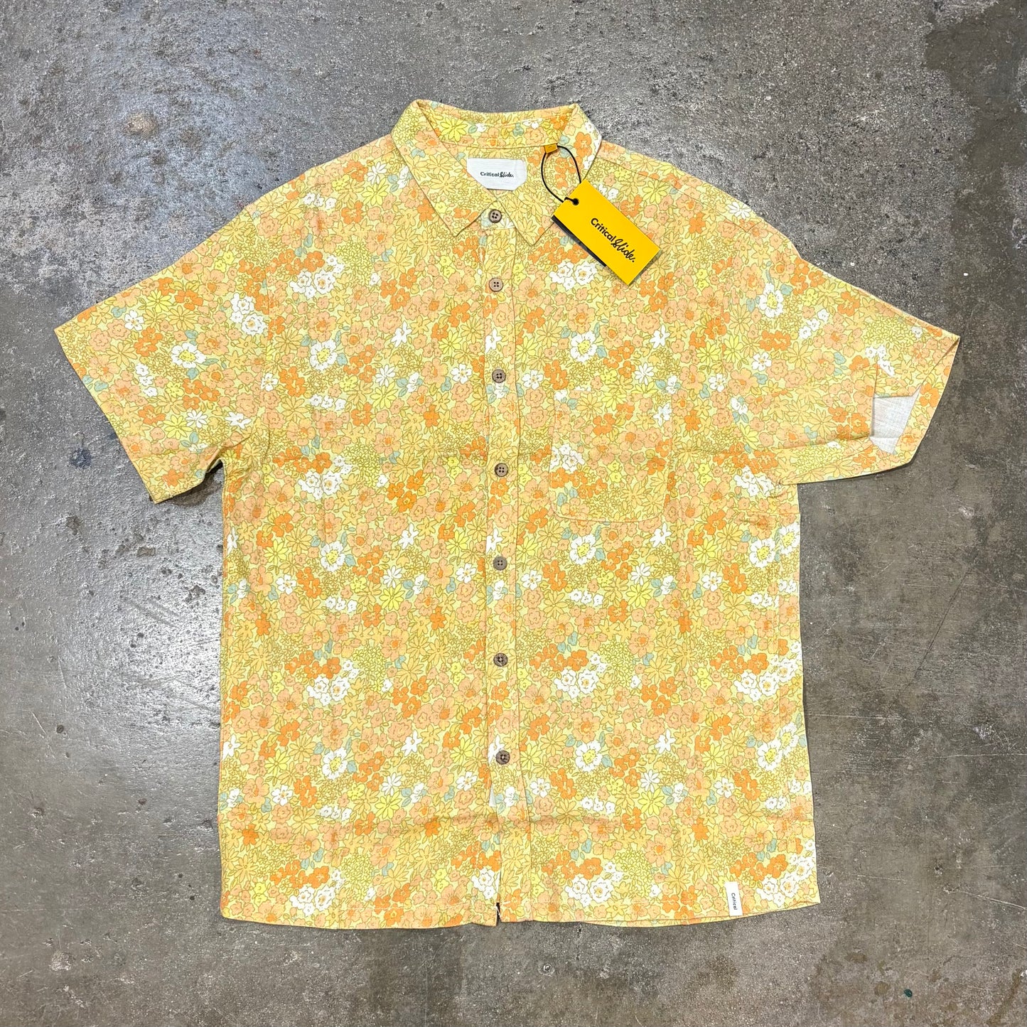 Floral patterned shirt with a tag on a gray surface