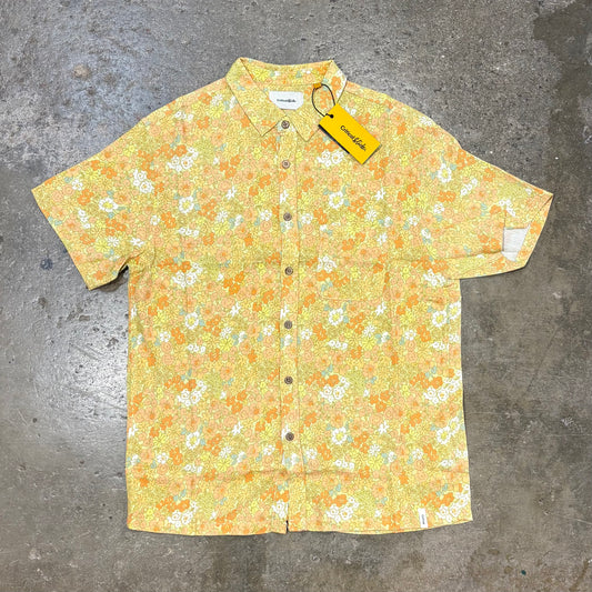 Floral patterned shirt with a tag on a gray surface