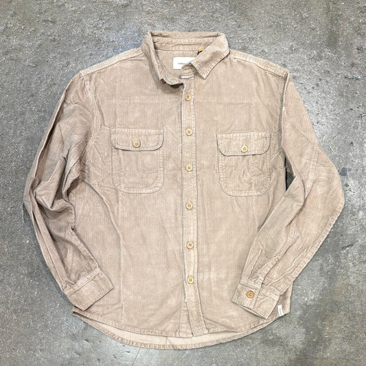 Beige button-up shirt on a gray concrete surface