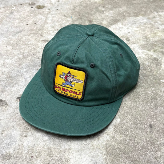 Green cap with a patch on a concrete surface