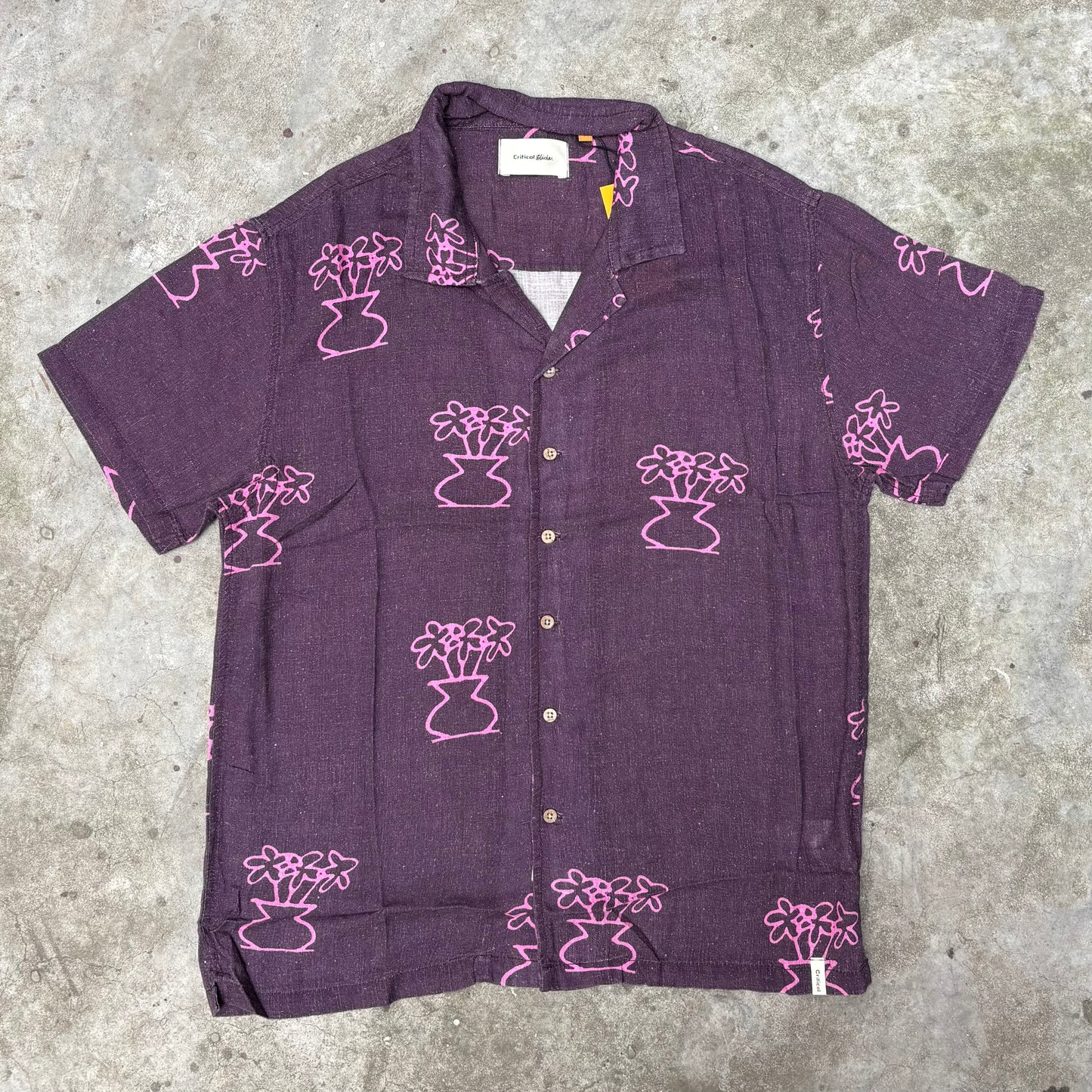 Purple shirt with pink floral patterns on a concrete surface