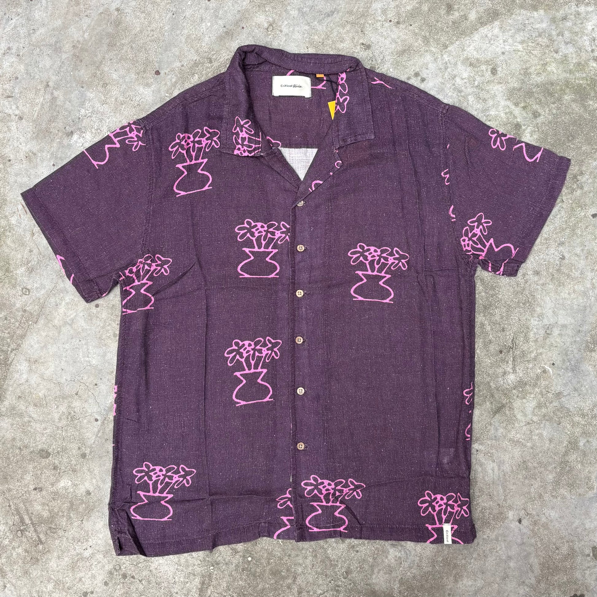 Purple shirt with pink floral patterns on a concrete surface