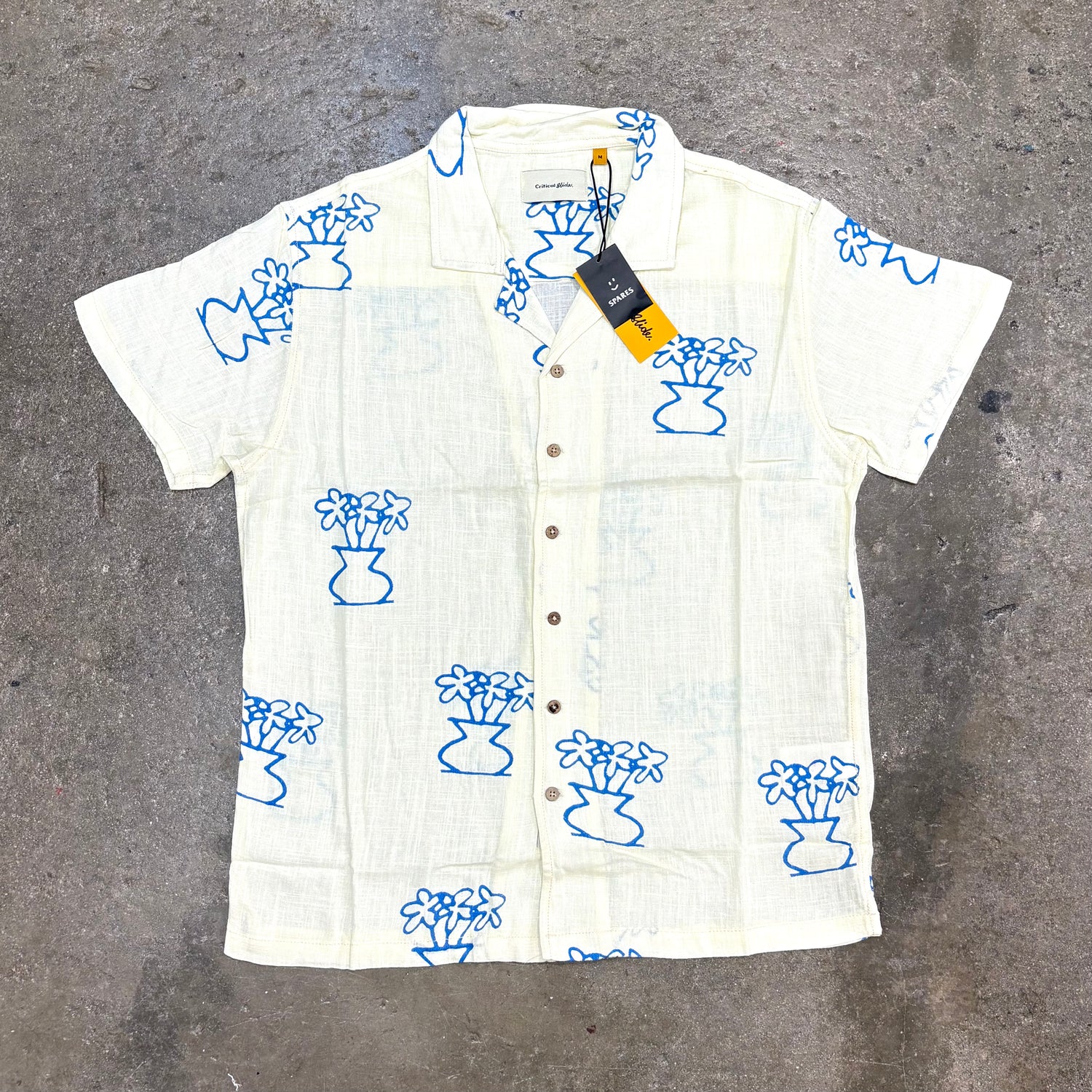 White shirt with blue floral patterns on a gray surface