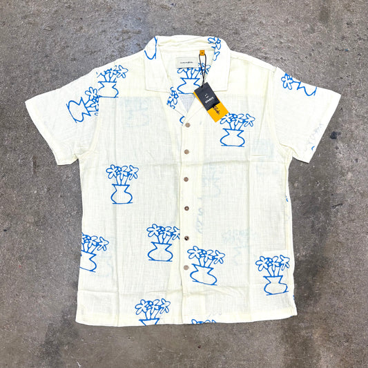 White shirt with blue floral patterns on a gray surface