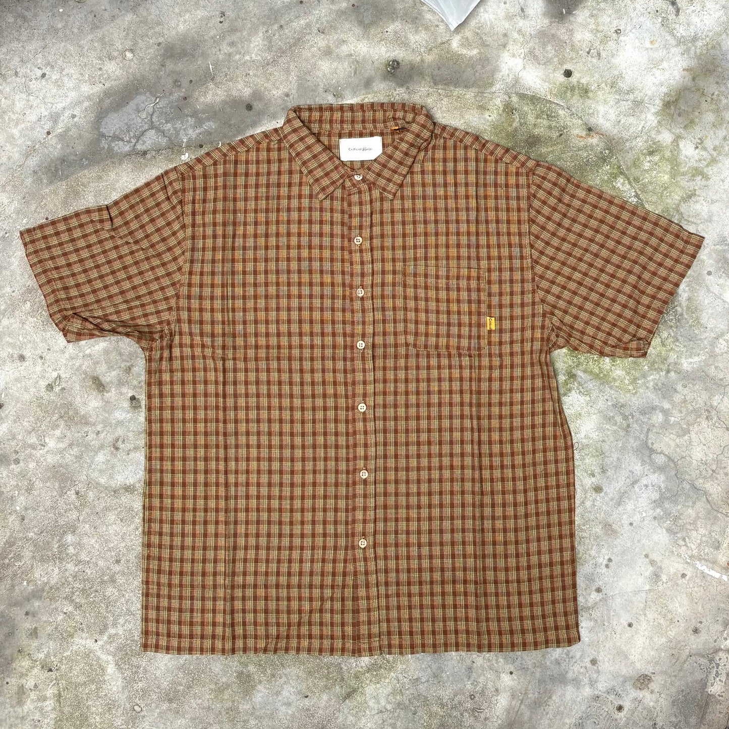 Brown checkered shirt on a textured concrete surface