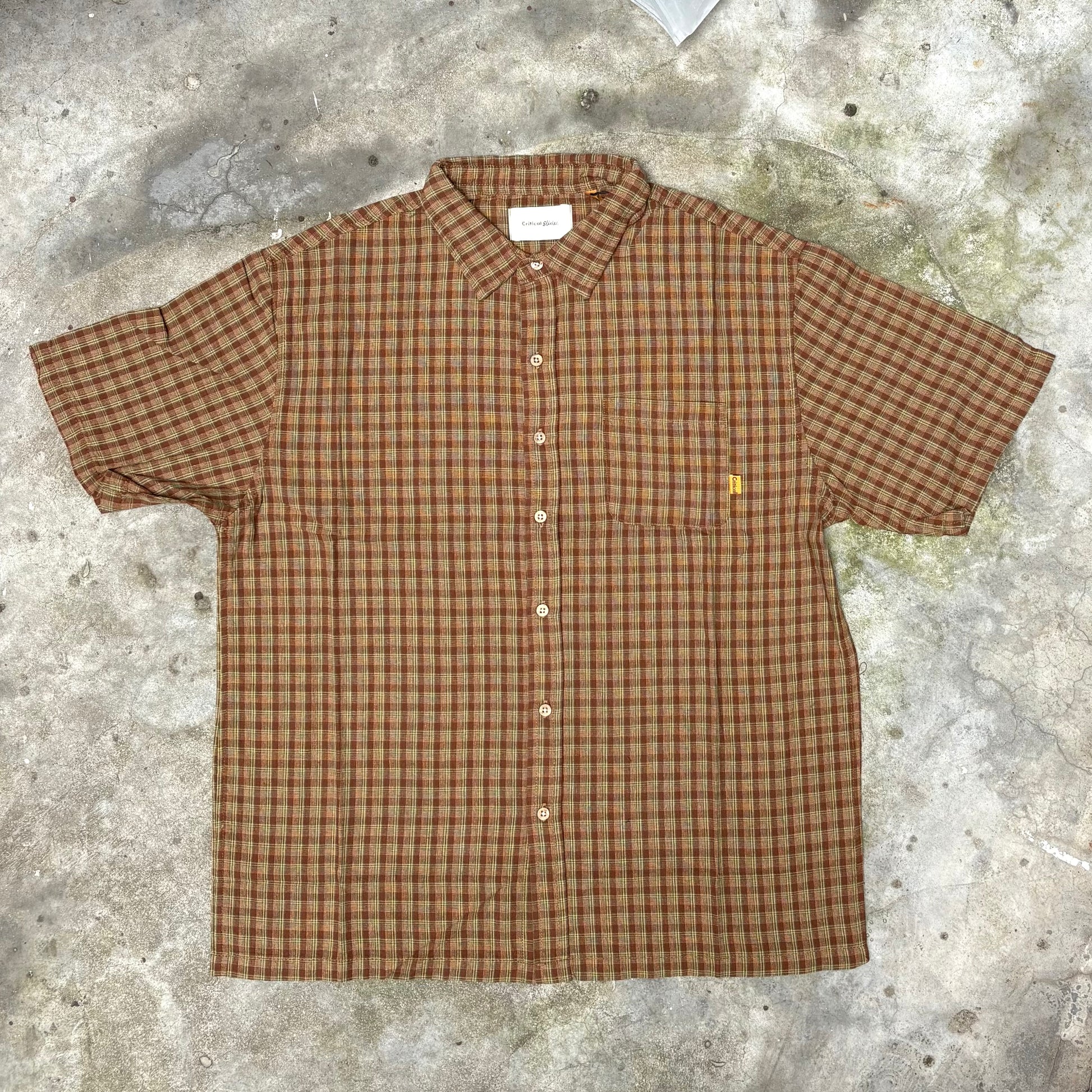 Brown checkered shirt on a textured concrete surface