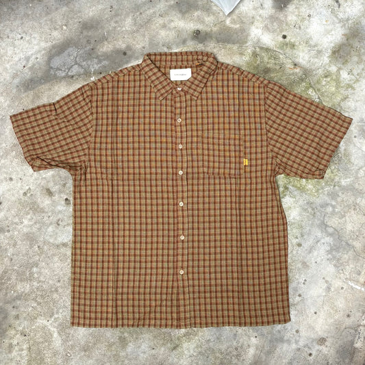 Brown checkered shirt on a textured concrete surface
