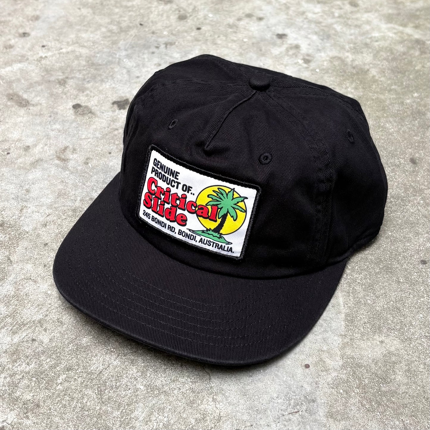 Black cap with badge on concrete surface