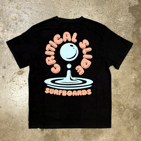 Black t-shirt with 'Critical Slide Surboards' graphic on a textured surface